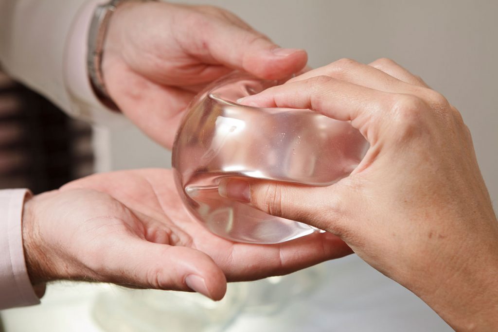 Patient squeezing a breast implant during a consultation