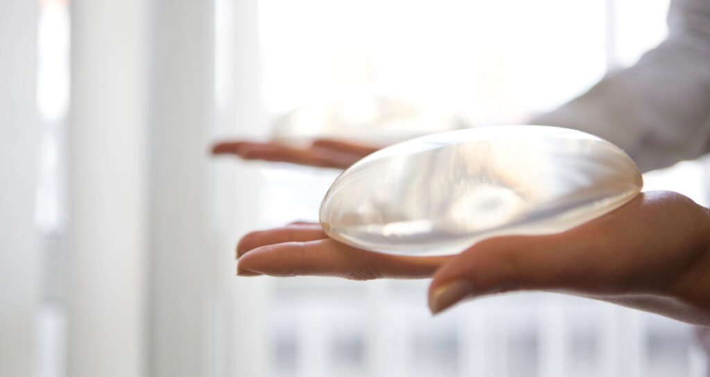 Close up of hands holding silicone breast implants