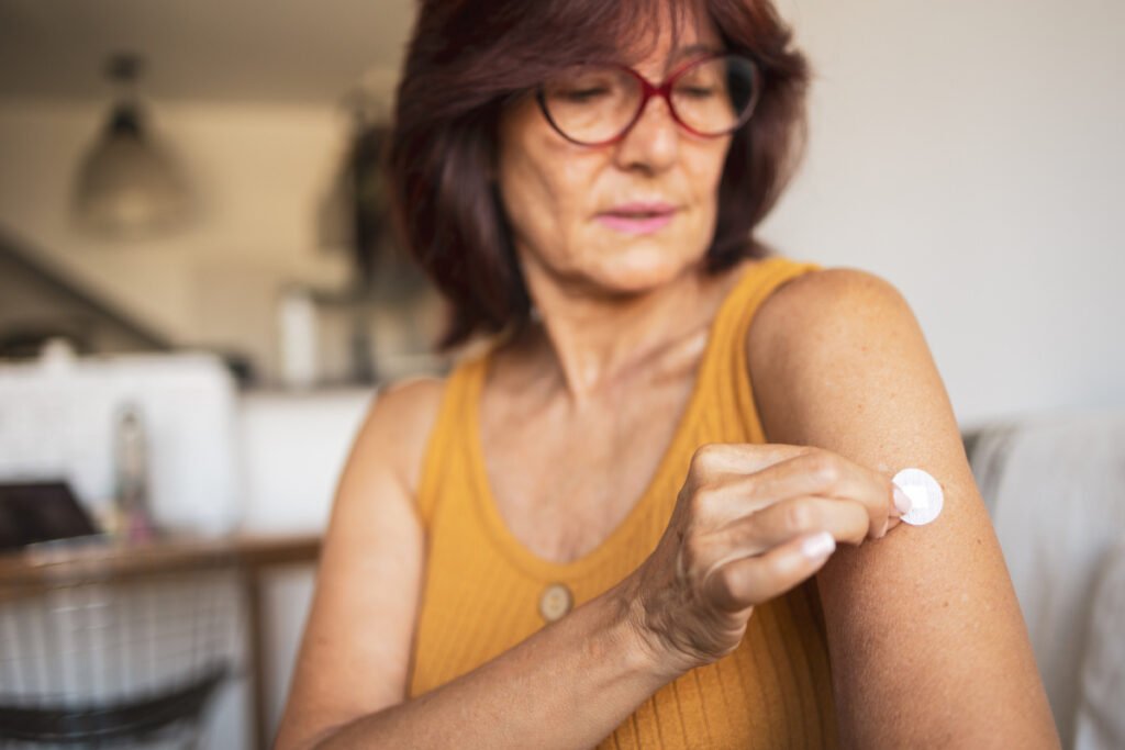 Woman applying HRT patch