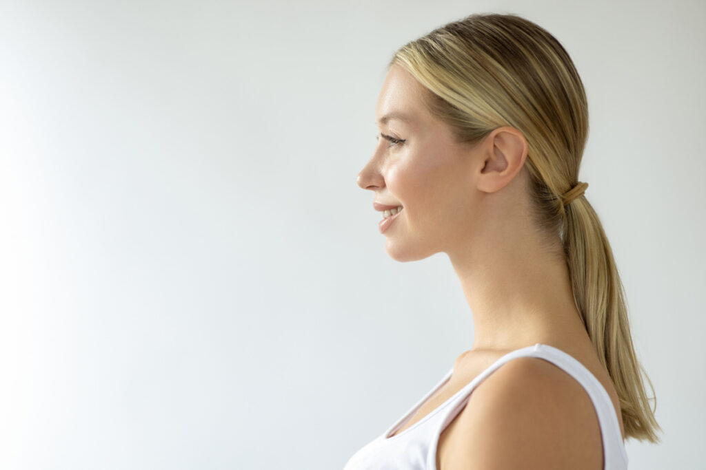 Side profile view of young blonde woman smiling